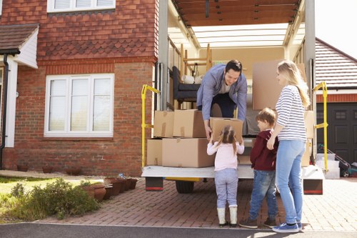 Family packing furniture for household storage in Barkingside
